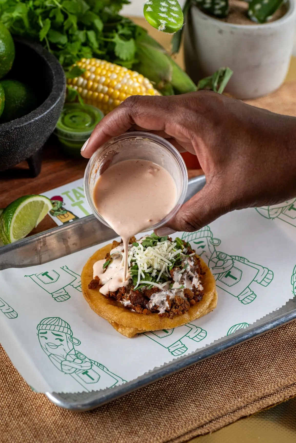 Taylor's Tacos Chicago signature creamy chipotle sauce being poured over a freshly made taco — live catering Chicago