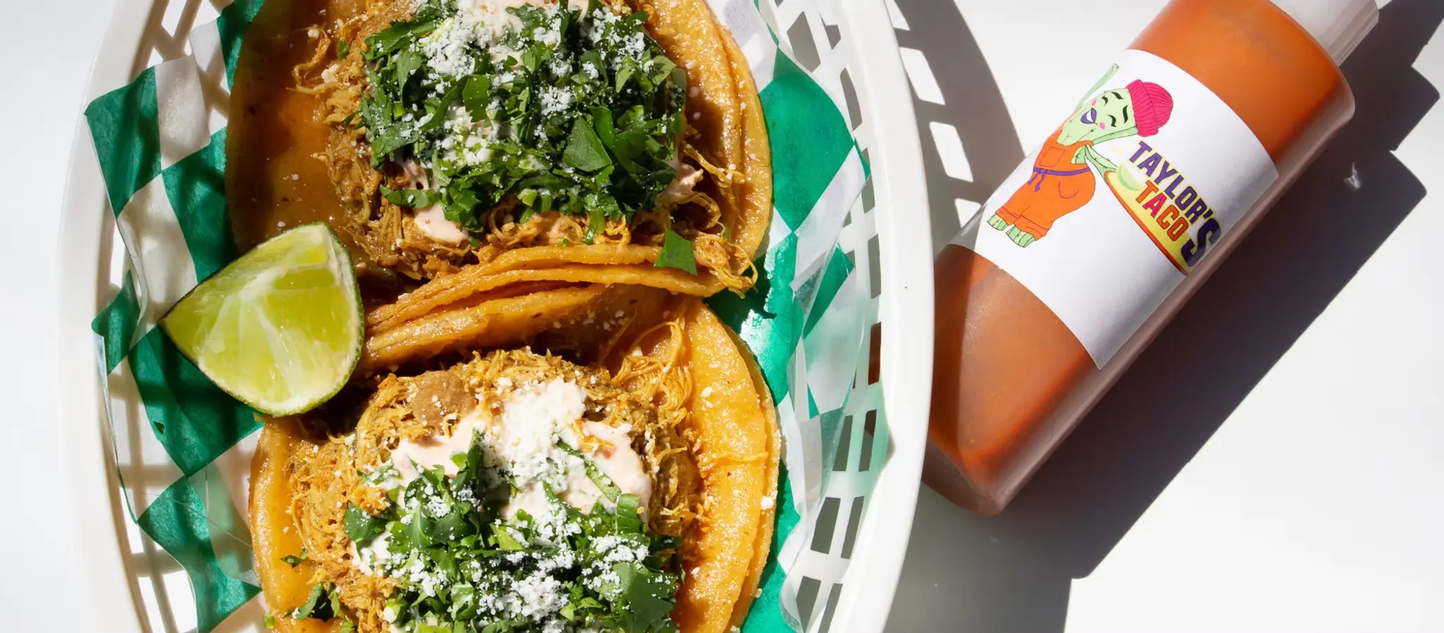 Taylor's Tacos Chicago birria tacos in basket with house hot sauce