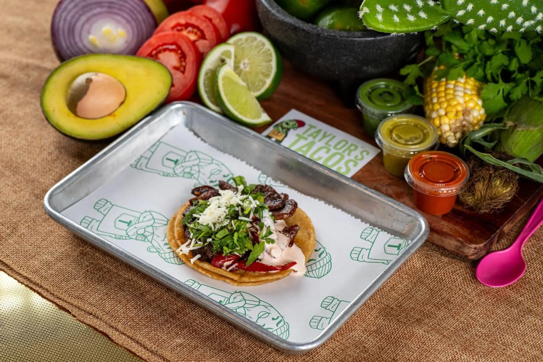 Taylor's Tacos Chicago savory steak taco with fresh avocado, cilantro, creamy sauce and shredded cheese on a corn tortilla